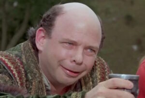 A color image showing Sicilian mastermind Vizzini from the 1987 classic The Princess Bride holding up a goblet.